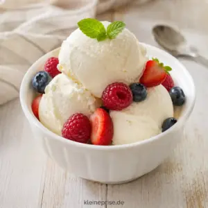 Low Carb Frozen Joghurt ohne Eismaschine selber machen Low Carb Frozen Joghurt mit Himbeeren, Blaubeeren und Erdbeeren in einer weißen Schale