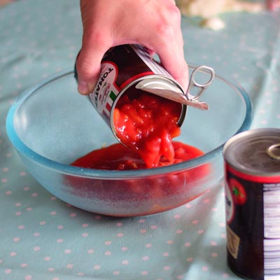 5. Schritt - Für den Belag: Die Dosen-Tomaten in eine Schale geben