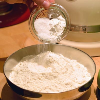 1. Schritt - Pizzateig mit Backpulver: In das Mehl kommt Salz und Backpulver hinein