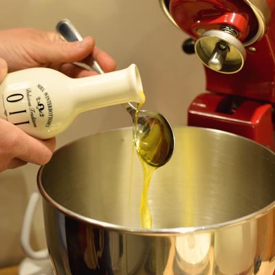 1. Schritt - Pizzateig mit Olivenöl: 10 Esslöffel Olivenöl abmessen und in die Schüssel geben