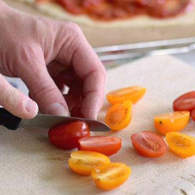 3. Schritt - Cherrytomaten halbieren: Mit einem Küchenmesser die Tomaten halbieren